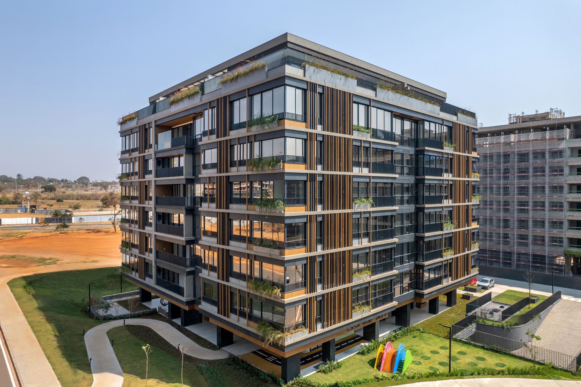 Edifício residencial da Tecna com fachada de brises de madeira e jardins
