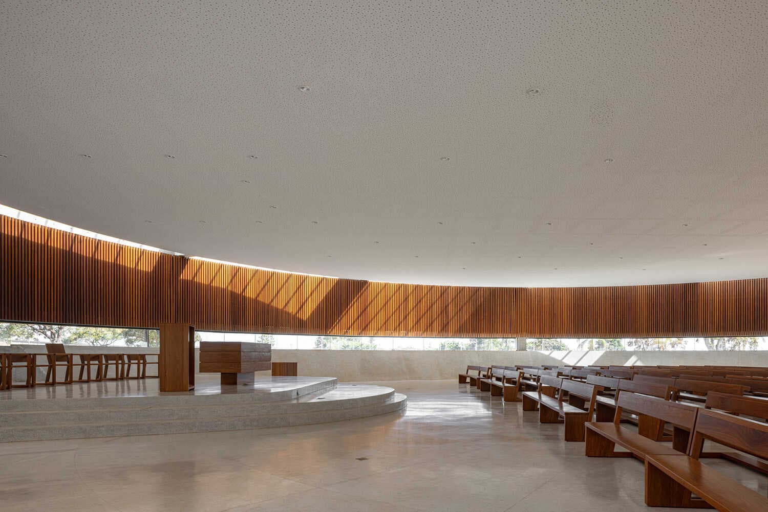 Interior da nave com brise curvo de madeira e bancos